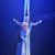 A performer is suspended mid-air, striking a dramatic pose with outstretched arms, wrapped in long fabric from an aerial silk performance, against a starry backdrop.