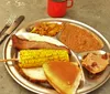 The image is a collage of four different photos themed around a traditional Western or cowboy lifestyle featuring musicians in cowboy attire a person smoking meat old-fashioned kitchen items and a plate of hearty food typically found in American Western cuisine
