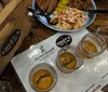 The image shows a table at a barbecue restaurant with a plate of food three glasses of whiskey and a menu featuring the Mint Julep and Edleys Bar-B-Que branding
