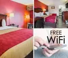 The image displays a neatly arranged hotel room with two queen-size beds a bold red accent wall and simple decor suggesting a comfortable and straightforward accommodation