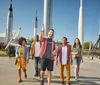 A group of people are enjoying their visit to a space center with rockets on display in the background