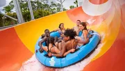 A group of people are enjoying a water slide ride together in an inflatable raft.