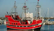 A red boat designed to look like a pirate ship, named 