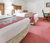 The image shows a neatly arranged hotel room with a large bed patterned carpet a sofa and decorative elements creating a cozy environment