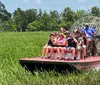 A group of tourists is enjoying a ride on an airboat through a wetland area