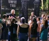 A group of people is attentively listening to a guide at the entrance of what appears to be a Vampire Tour