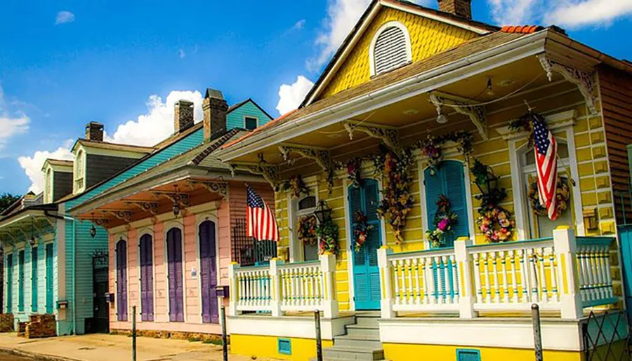 The image shows colorful traditional shotgun-style houses adorned with decorations and American flags, likely in New Orleans.