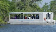 Passengers on a Louisiana Swamp Tours boat observe the surrounding wetlands.