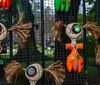 The image features a collection of whimsical stylized dolls with button eyes and stitched features reminiscent of characters from a Tim Burton film displayed against a mesh background