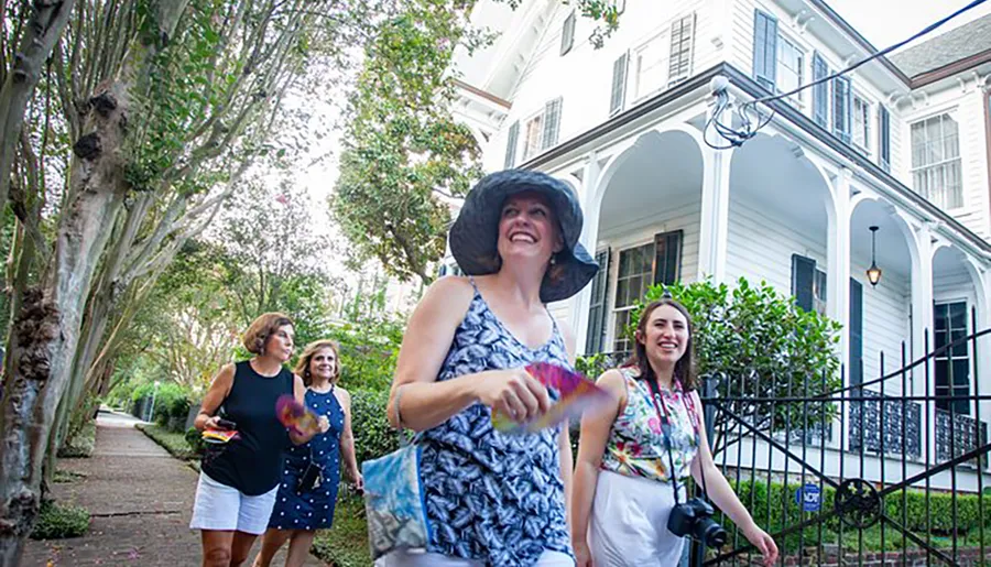 A group of women appear to be enjoying a walking tour in a residential area, with one cheerfully leading the way.