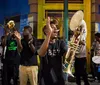A lively brass band performs on a vibrant street at night