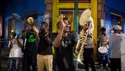 A lively brass band performs on a vibrant street at night.