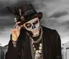 A person dressed in a suit with skull face paint tips their hat in a graveyard with a dramatic cloudy sky in the background