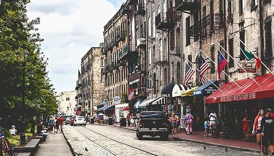 The image depicts a bustling, historic city street with pedestrians, parked cars, and lined with American flags and various storefronts.