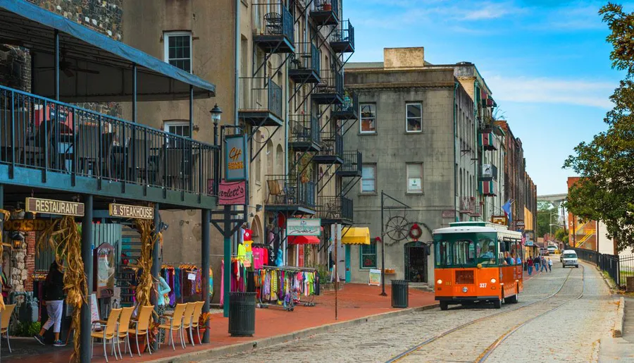 The image features a colorful street scene with an orange streetcar running down the tracks, flanked by eclectic buildings and various shops displaying goods outside.