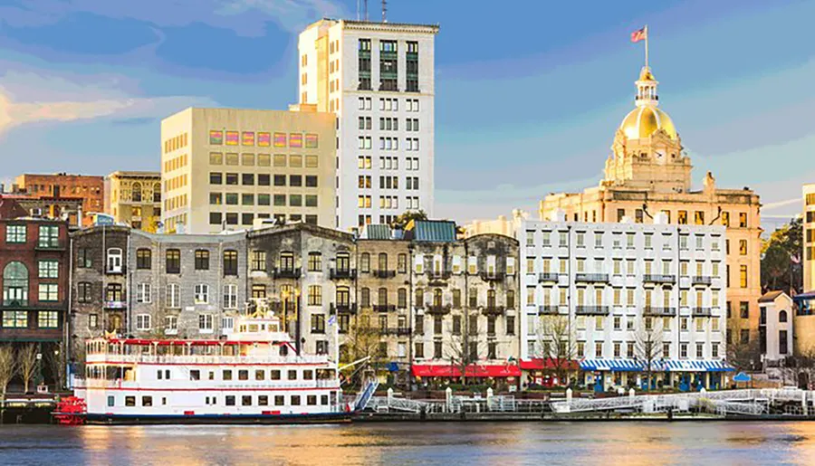 The image shows a waterfront scene with a mix of historic and modern buildings, a riverboat docked along the pier, and a prominent building with a golden dome in the background.