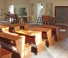 This image shows a vintage classroom setting with wooden desks a blackboard and traditional school furnishings suggesting a historical or educational exhibit