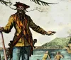 The image depicts a colorful illustration of a classic pirate with a red hat and a long beard standing on shore with a smoking pipe in his mouth gesturing towards a ship at sea while two other figures work in the foreground