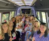A group of smiling people is having a good time together inside a well-lit party bus or limousine