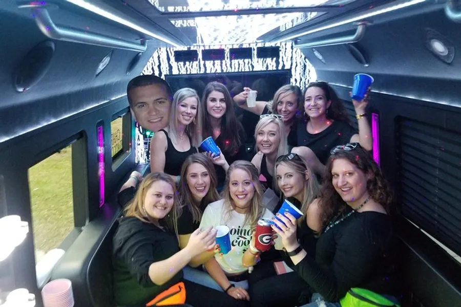 A group of people celebrating inside a limousine, with one person holding up a cutout of a man's face.