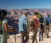 Two hikers are taking a selfie with the expansive view of the Grand Canyon in the background