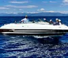 A group of people are enjoying a sunny day on a white speedboat on a calm blue sea