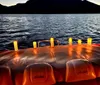 A group of people is enjoying a boat ride on a body of water with a beautiful sunset in the background