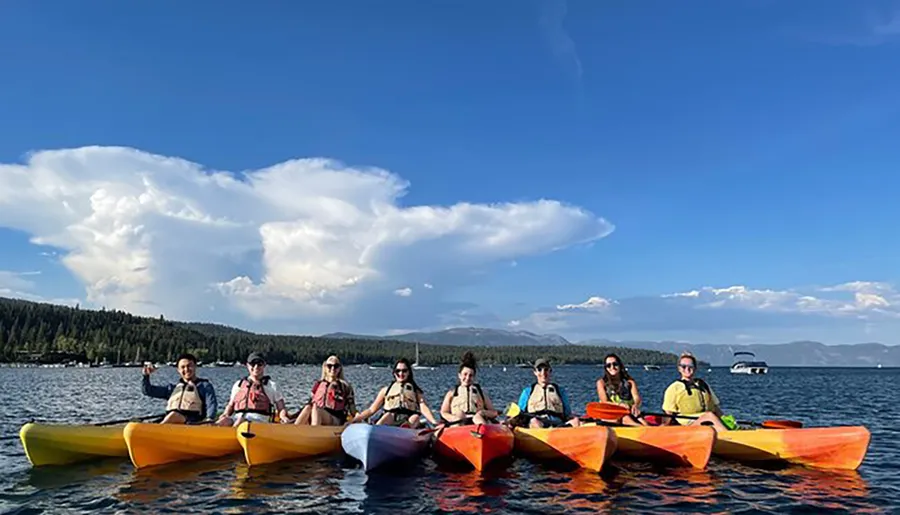 A group of people enjoy kayaking together on a calm lake under a sky with impressive cloud formations.