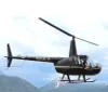 A helicopter with the registration N654LH is flying near mountainous terrain with a visible pilot