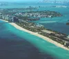 An aerial view of a sunlit Miami Beach coastline showcasing high-rise buildings pristine sands and a vibrant blue ocean