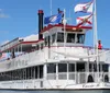 A paddlewheel boat named Carrie B adorned with flags sails under a blue sky