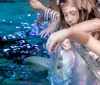 Children are gently touching and interacting with a fish in a touch tank at an aquarium