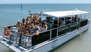 A group of people are enjoying a sunny day on a Coastal Cruises tour boat.