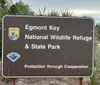 The image shows a sign for Egmont Key National Wildlife Refuge  State Park with the motto Protection through Cooperation featuring logos of the US Fish  Wildlife Service and the Florida Park Service