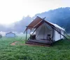 A glamping site with luxurious tents nestled in a misty valley during the early morning hours