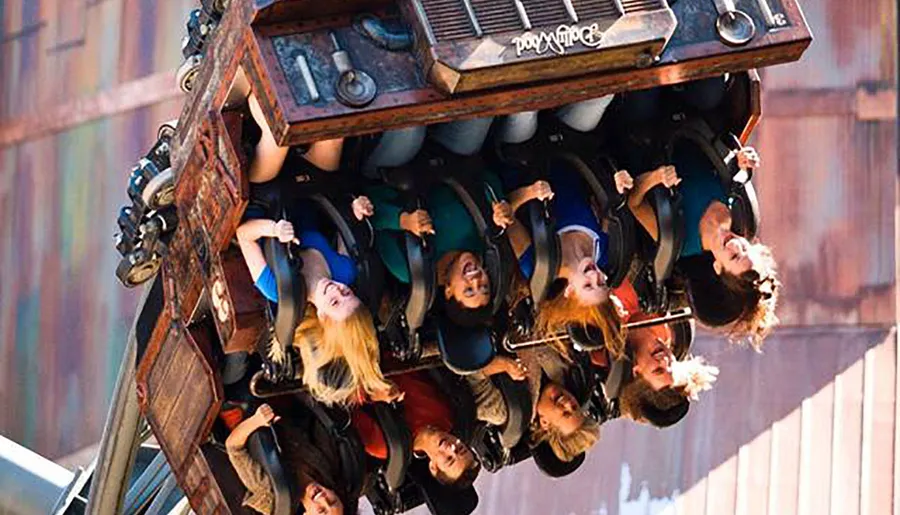 A group of people are upside down on a thrill ride, expressing excitement and exhilaration.