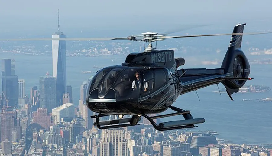 A helicopter flies over a cityscape with a distinct skyscraper in the background.