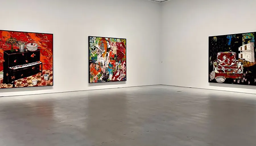 The image shows a modern art gallery room with three large, colorful abstract paintings displayed on white walls.