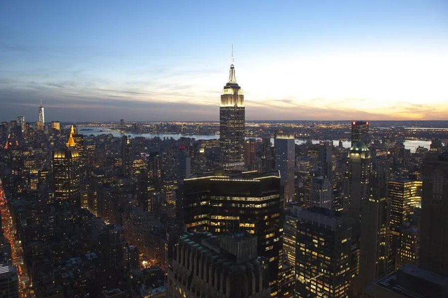 The image captures a dusk view of the New York City skyline with the Empire State Building prominently in the foreground.