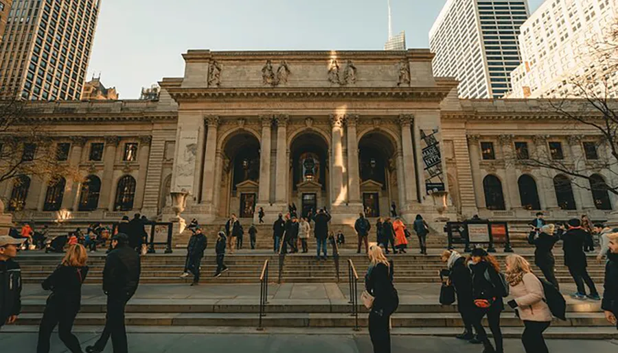 People are seen walking up and down the steps of a grand historic building with classical architecture, likely a library or museum, bathed in the warm light of a setting or rising sun.