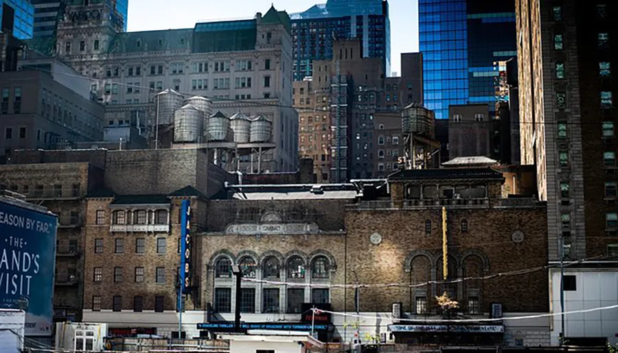 The image shows an eclectic mix of old and newer urban buildings with water towers atop, which could be a bustling metropolis like New York City.