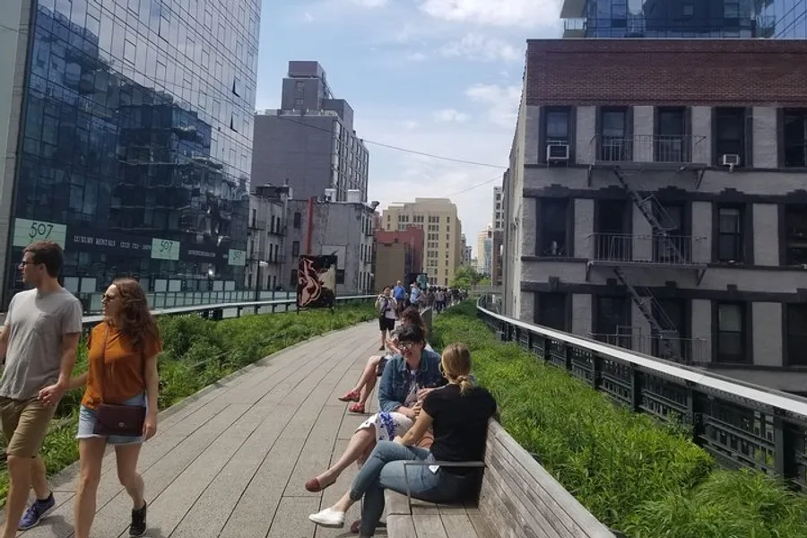 The image shows people walking and sitting along a landscaped elevated park with city buildings on each side, which is reminiscent of the High Line in New York City.