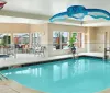 The image features an indoor swimming pool with playful graphics of a butterfly and a whale superimposed on the ceiling