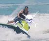 A person is riding a jet ski on choppy water with a stylized skull and crossbones graphic superimposed on the image