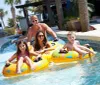 Four people are enjoying a sunny day floating down a lazy river on colorful inner tubes