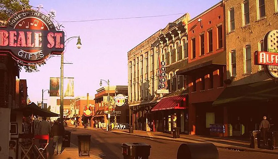 The image captures a vibrant street scene on Beale Street in Memphis, Tennessee, known for its significant role in the history of blues music, featuring colorful storefronts, neon signs, and people walking.