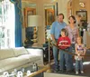A family of four is observing a well-decorated room with two children wearing audio guides indicating they are likely on an audio-guided tour