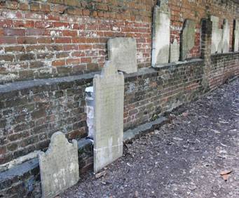 Grave markers along brick wall