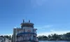A decorated boat is docked beside a calm waterfront under a clear blue sky.