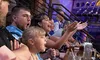 A group of spectators are enthusiastically cheering and clapping at an event, with expressions of excitement and engagement on their faces.